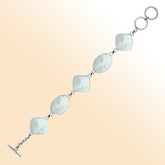 Handcrafted silver bracelet with oval and cushion mother of pearl links, elegant artisan design.